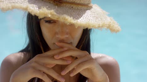 mujer atractiva y reflexiva con un sombrero de paja