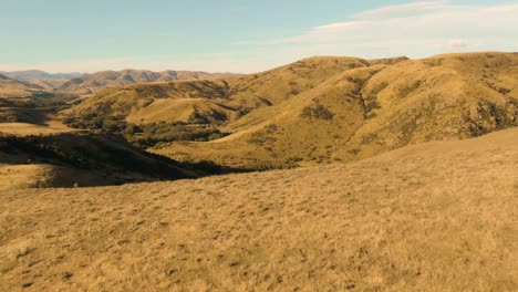 Drone-reveal-of-rolling-hillsides-during-golden-hour