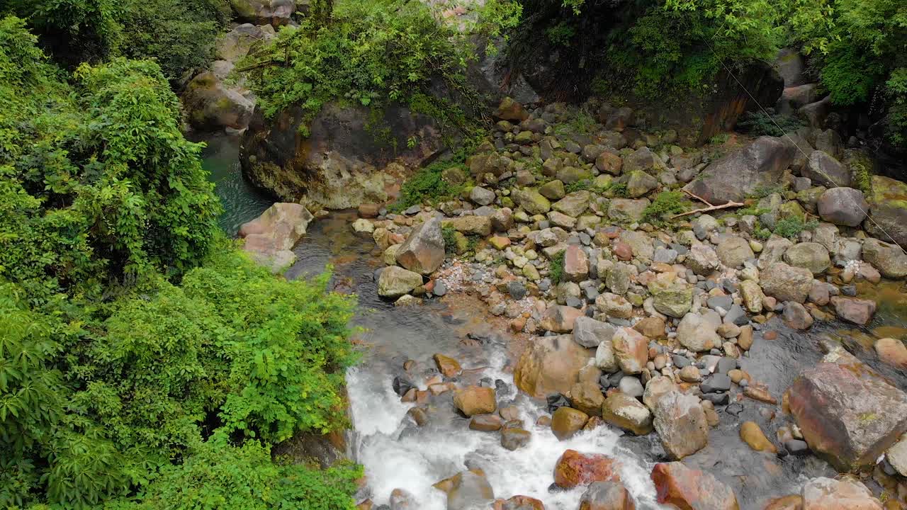 4k vuelo aéreo hacia atrás revela toma de personas caminando en el puente colgante en el bosque de cheerapunji, meghalaya, india