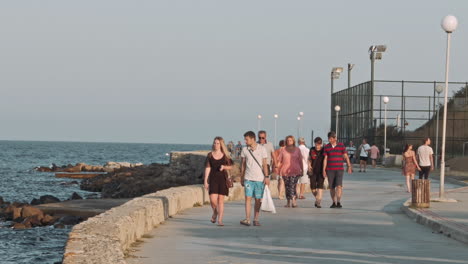 people walking on a pier by the sea against sky
