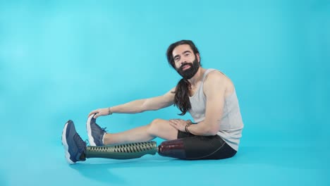 man with prosthetic leg stretching on a blue background