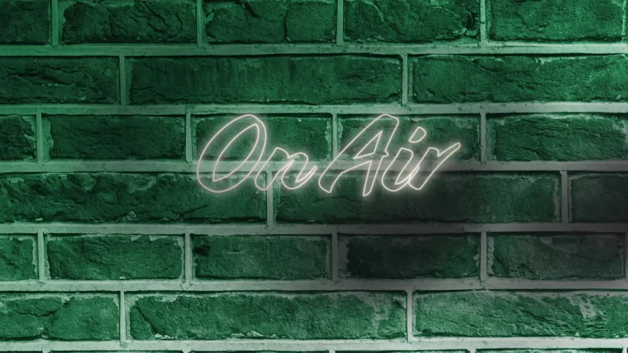 Neon on air text against green brick wall in background