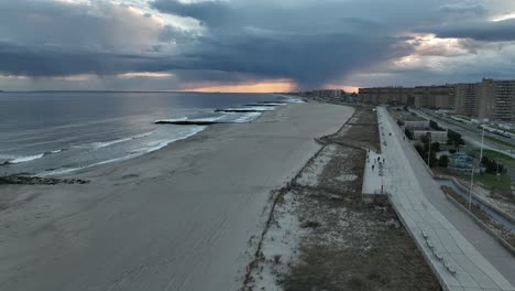 Una-Vista-Aérea-De-Una-Playa-Tranquila-En-Arverne,-Ny-Mientras-La-Lluvia-Cae-En-La-Distancia-En-Una-Noche-Nublada