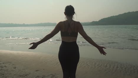 Girl-doing-yoga-on-the-beach-at-low-tide