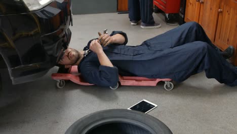 Handsome-mechanics-repairing-a-car