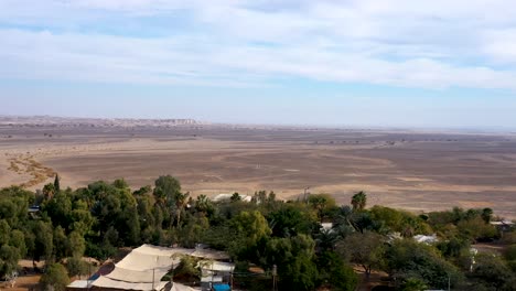 the drone flies over the village in the middle of the desert