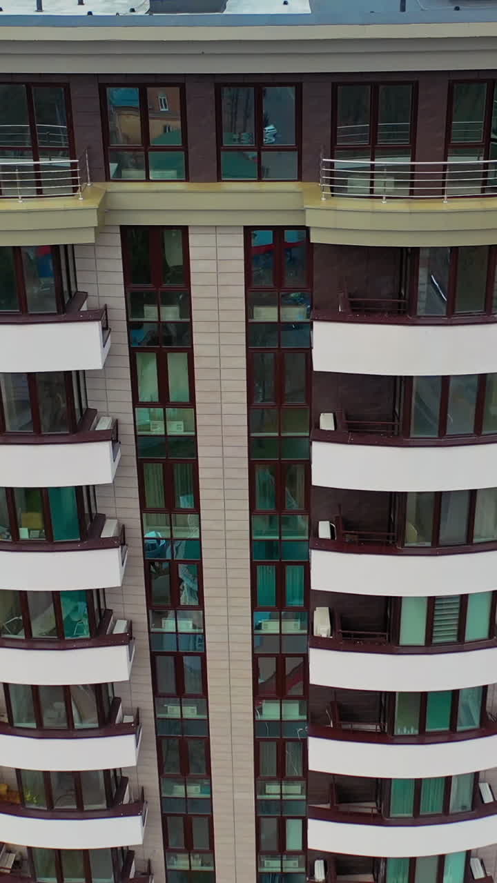 Futuristic architecture cityscape view. Aerial view of facade detail of modern high-rise apartments building. Vertical video