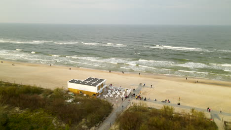 Tourists-enjoying-the-beach-and-waves-in-Wladyslawowo,-Poland--aerial