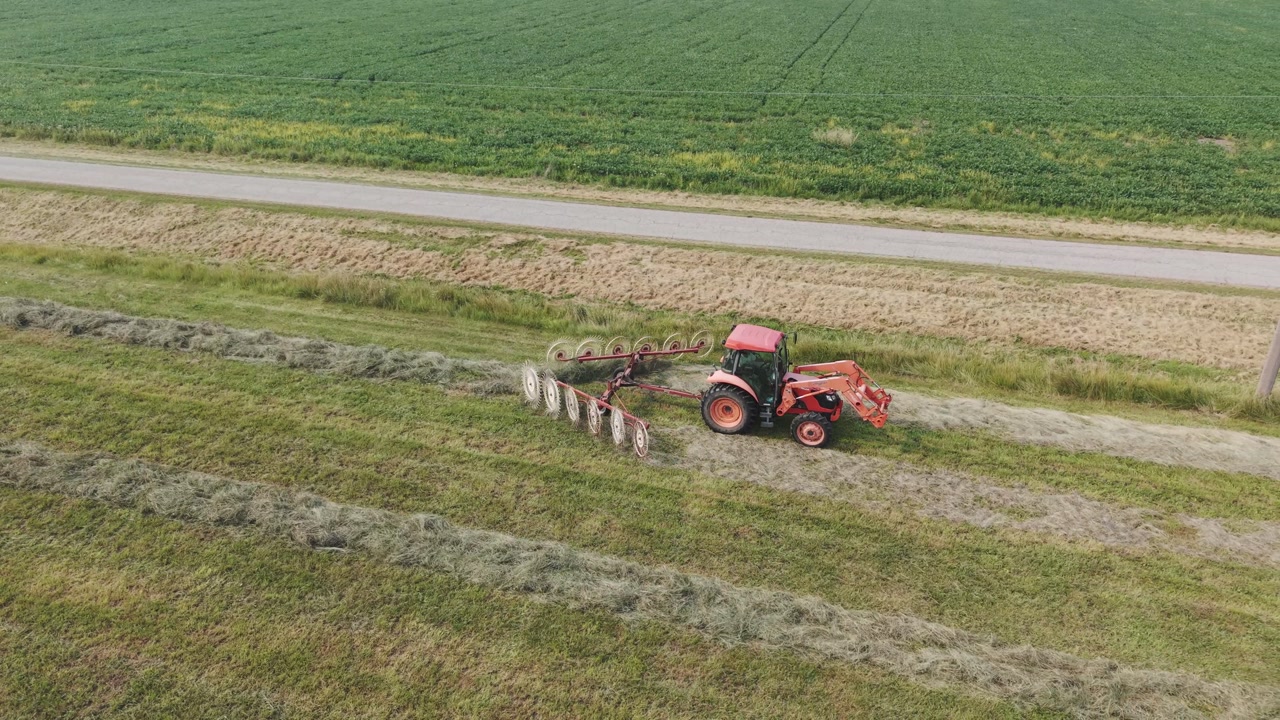 A farmer in northeast Wisconsin rakes recently cut hay into neat rows for harvest.