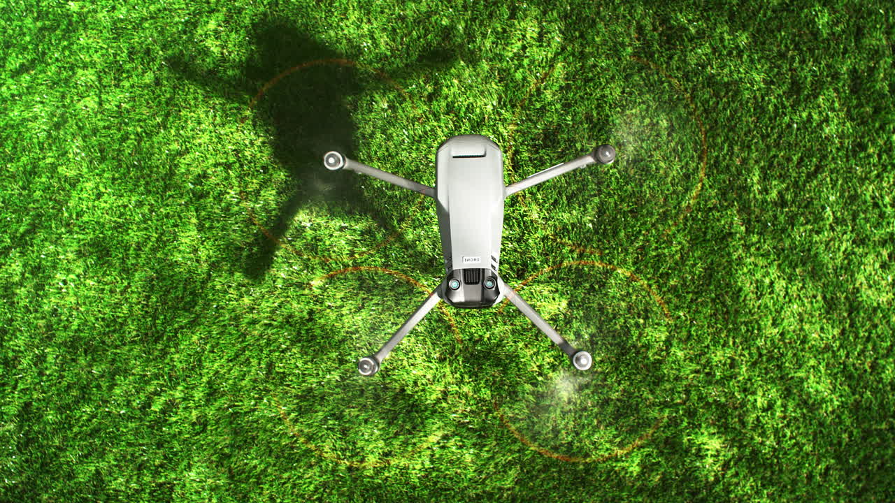 Landing Drone Slowly Rotates In The Air And Descends Onto Green Grass in Slow Motion, Top View