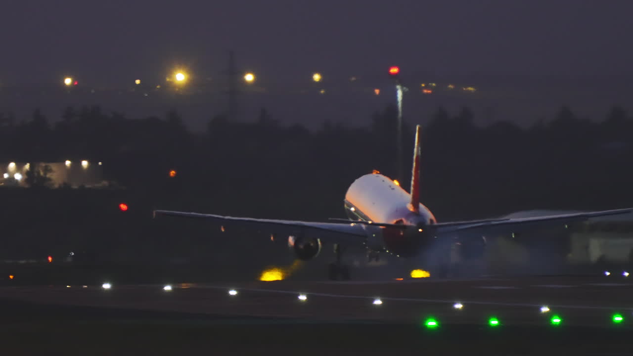 Aereo passeggeri commerciale che atterra sulla pista dell'aeroporto al tramonto