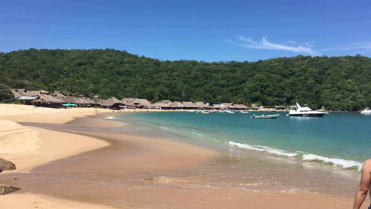 수영복을 입은 커플이 휴가를 즐기며 해변을 걷고 있다