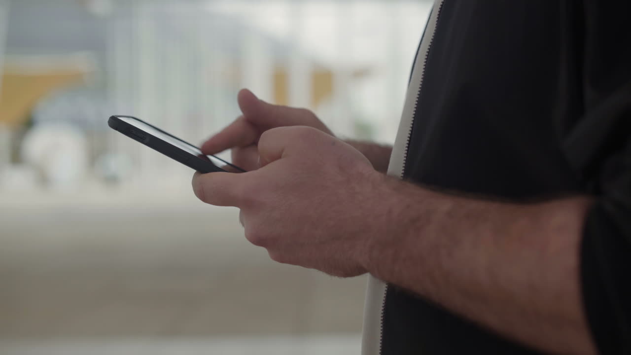 Vista laterale di mani maschili che scrivono messaggi sullo smartphone