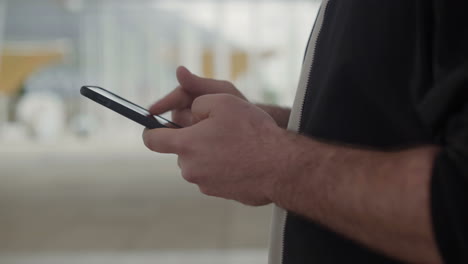 Side-view-of-male-hands-messaging-on-smartphone.