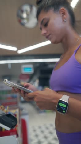 woman uses smartwatch and phone in a retail store