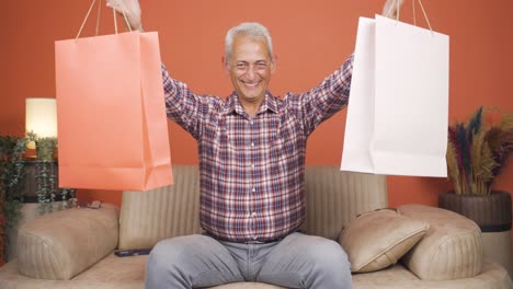 hombre mirando a la cámara con bolsas de compras.