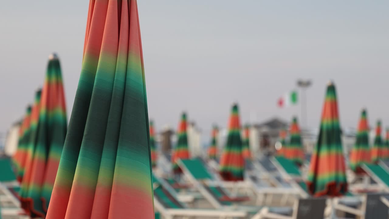 Colorful beach umrellas on a large sandy beach, blurred background