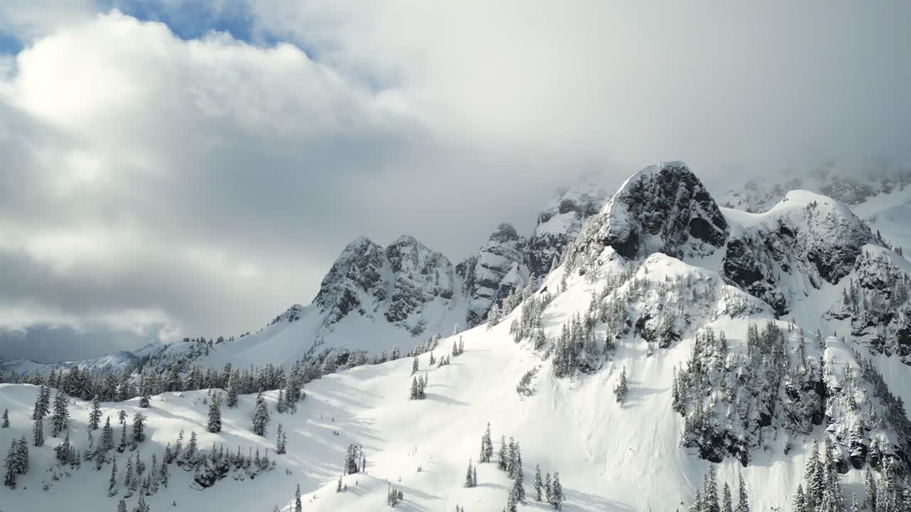 Atemberaubende schneebedeckte Berggipfel mit verschneiten Bäumen.
