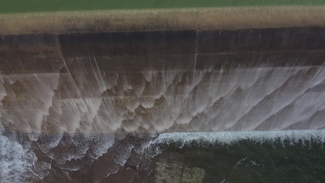 Water cascades over the high walls of the Asprokremmos Dam during a rare overload