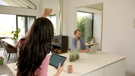 a young couple is using a smart home app on a tablet at home