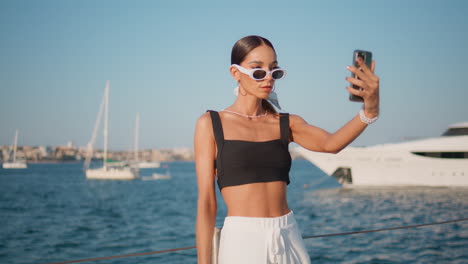 mujer tomando una selfie junto al yate