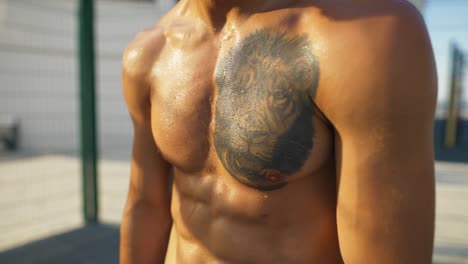 cuerpo sudoroso con tatuaje de león, concepto de cruz en forma