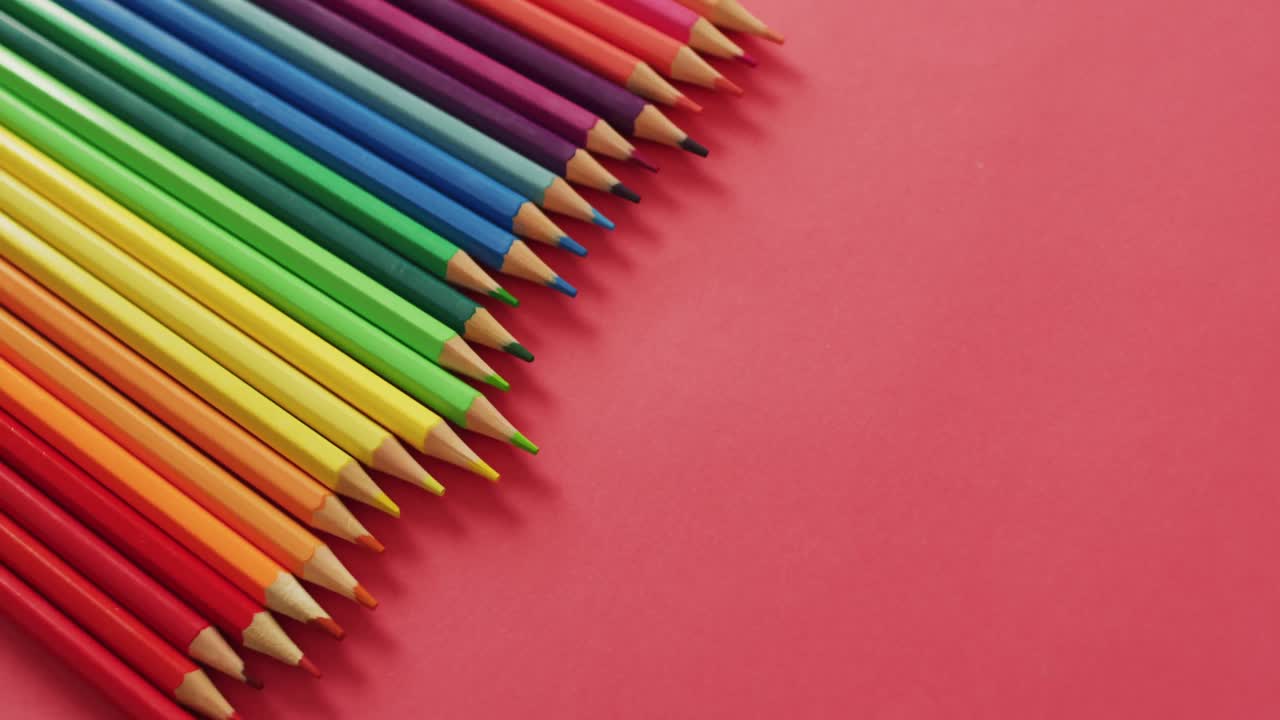 vídeo de la composición con lápices de colores en superficie roja