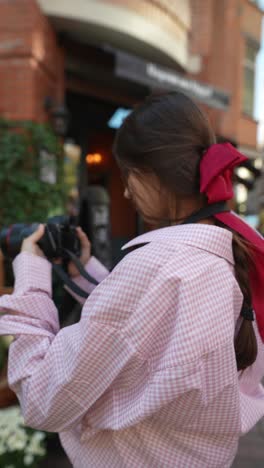 woman with red bow and camera on city street