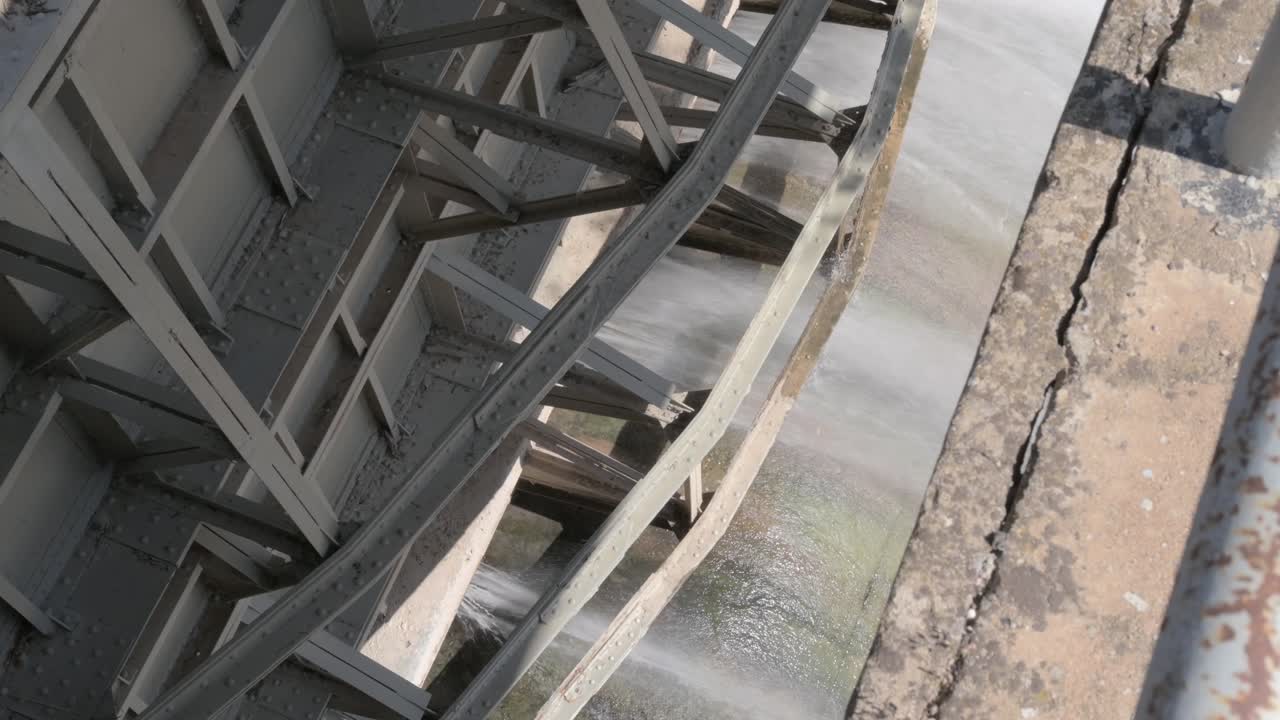 Close-up of water flowing through a gate mechanism in a dam on the Guadalquivir river