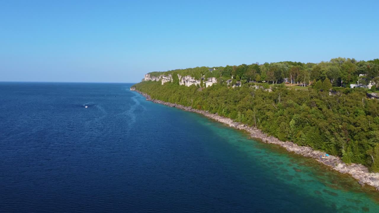 Lotniczy time-lapse pionowego klifu na Półwyspie Bruce'a pokrytego bujnymi sosnami, Zatoka Georgian