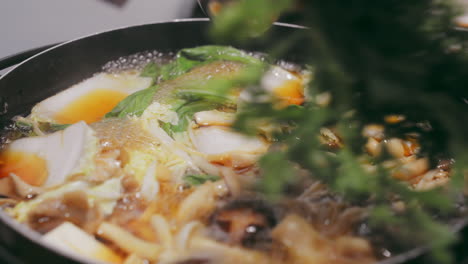 lush green vegetables are gently added to a steaming mushroom hotpot, creating a warm and inviting scene