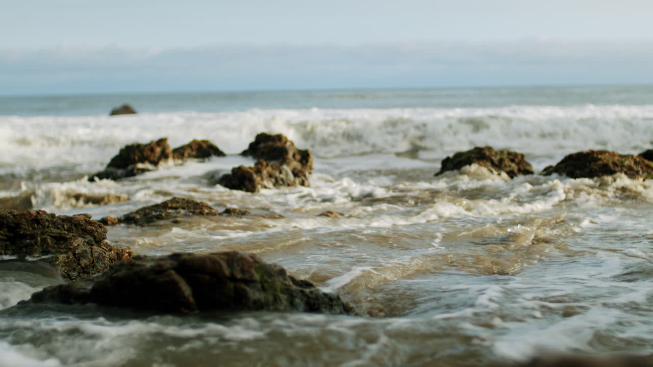 las olas del océano chocando contra la orilla rocosa