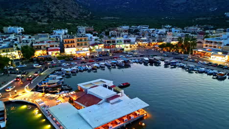 elounda port at twilight, with waterfront restaurants and vibrant lights