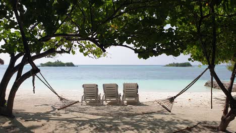 beach chairs  and hammock on seashore in maldives. lockdown shot