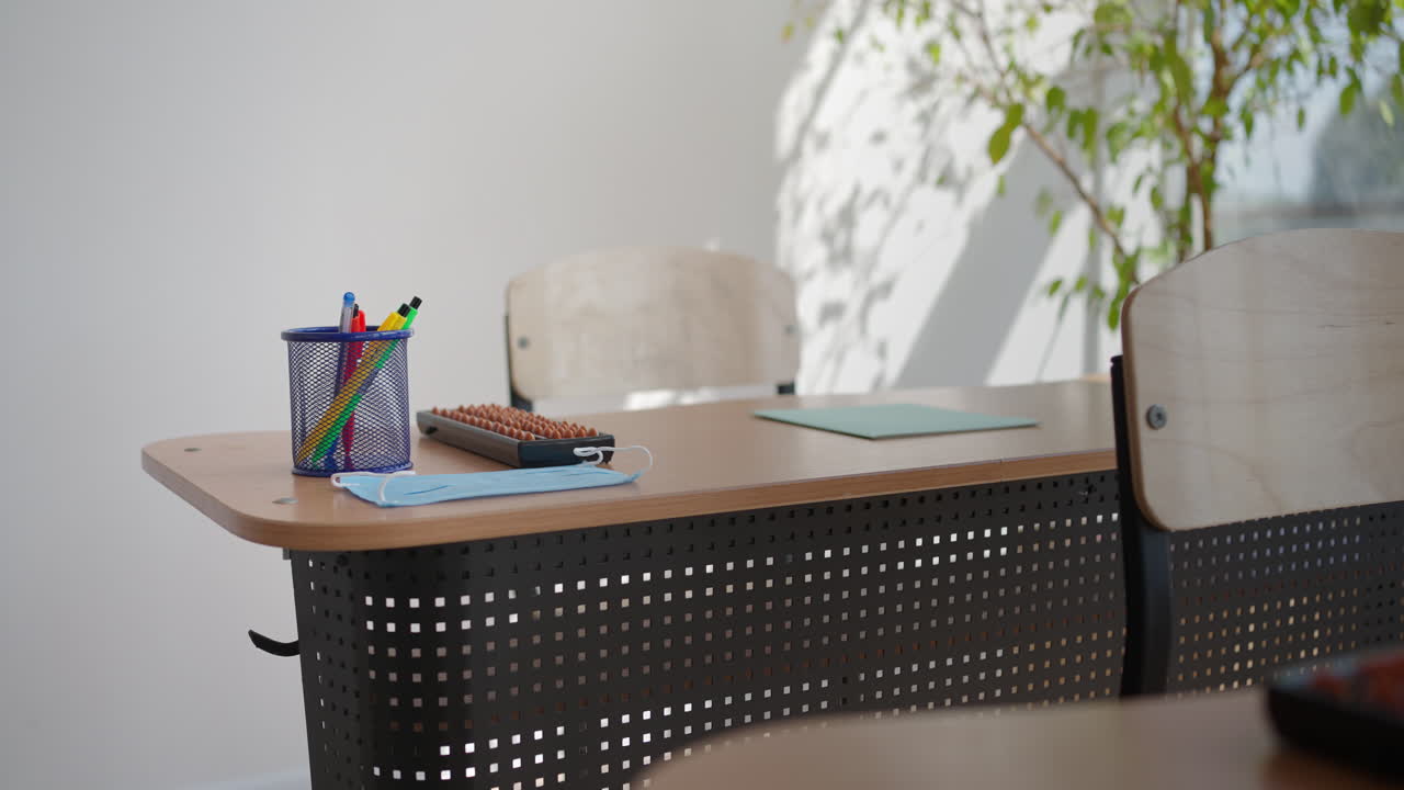 rayos de luz cayendo en el aula oscura vacía. la cámara panorámica detrás de filas de escritorios y sillas. clase de enseñanza sin estudiantes durante un descanso. escuela abandonada. estado de ánimo perturbador.