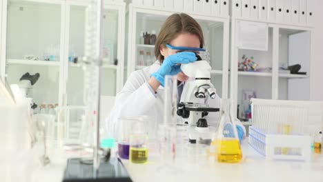 female scientist conducting research with a microscope in a laboratory