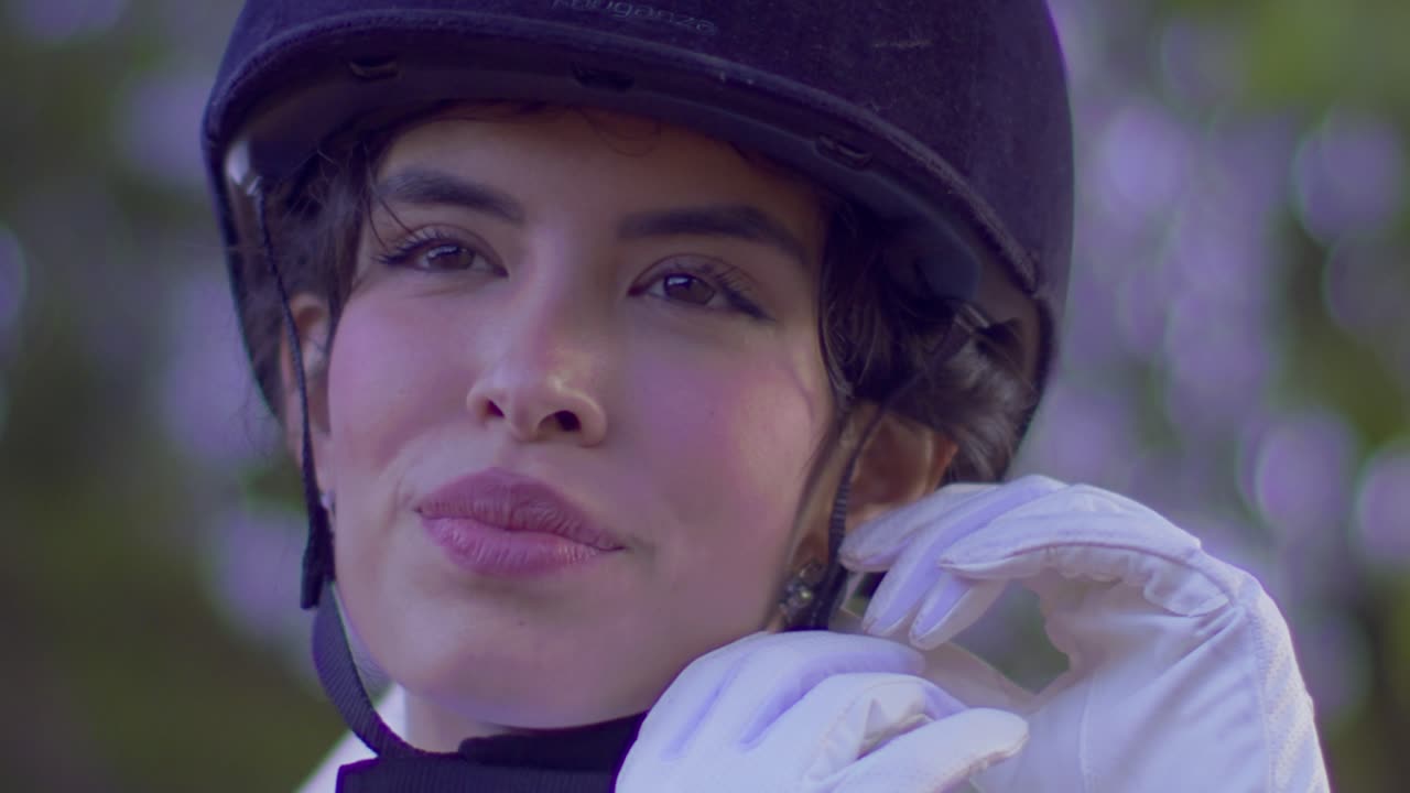 feliz ecuestre con casco de montar sonriendo después de la carrera de caballos