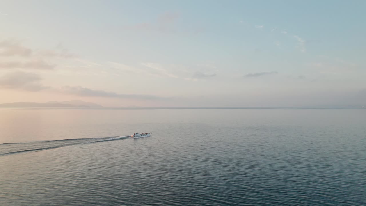 A motorboat sails Japanese Waters of Biwako lake, Panoramic drone, pink skyline