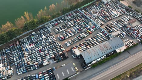 aerial view of big parking lot of junkyard with rows of discarded broken cars. recycling of old vehicles