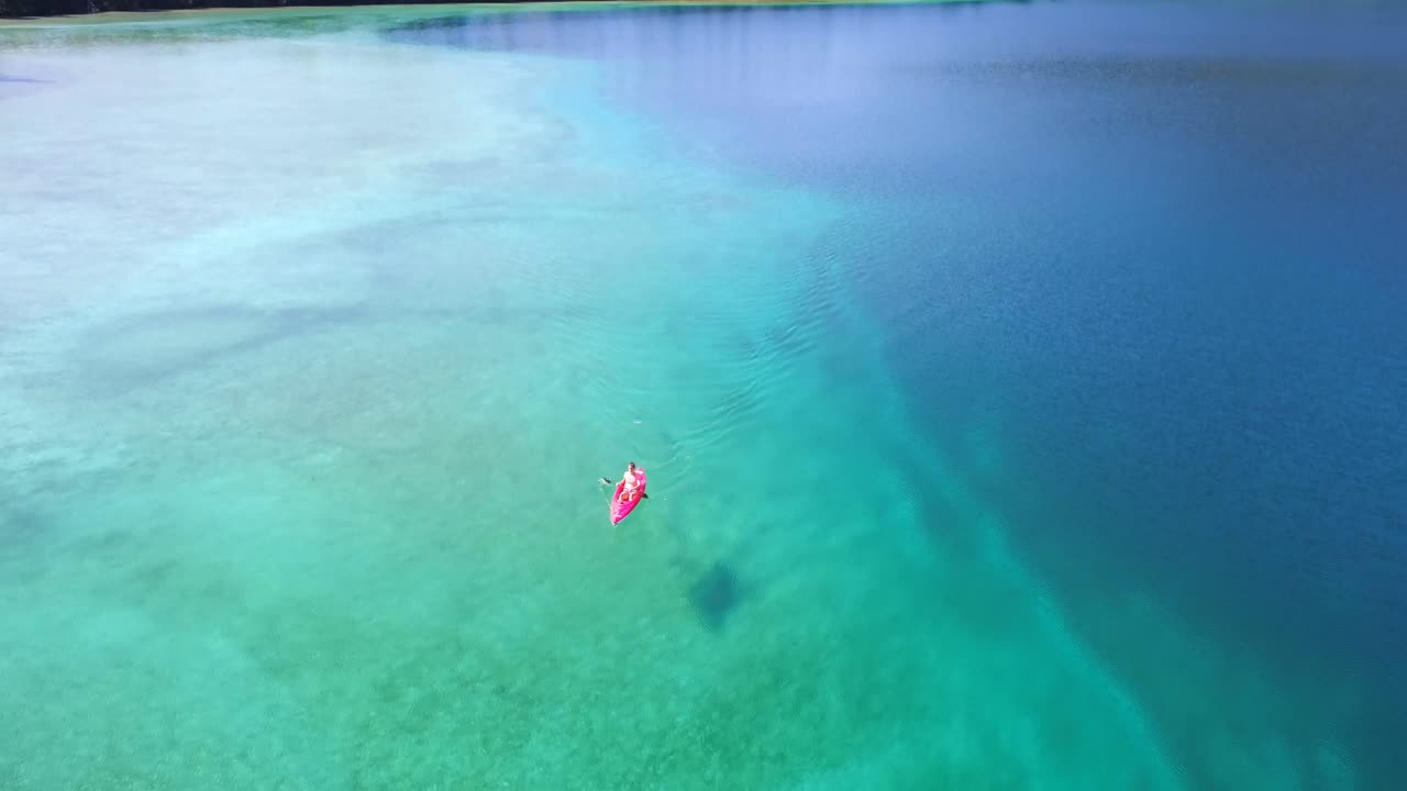 vista aérea de una mujer en kayak en un lago 4k