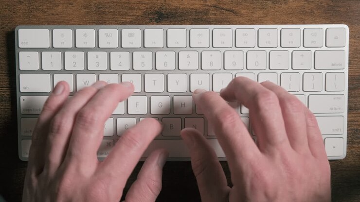 Closeup view of caucasian hands typing a fast text on keyboard at college