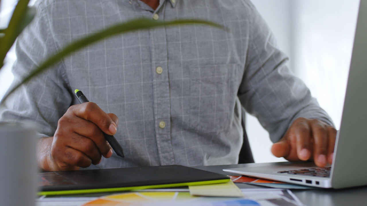 Businessman using graphic tablet on desk at office 4k