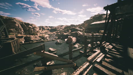 wooden bridge over a river in rocky landscapes under a blue sky