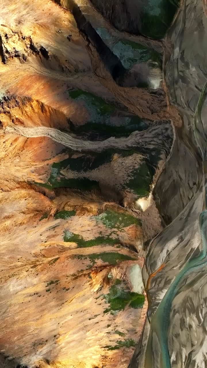 Colorful Icelandic hills reveal sweeping mineral bands, mossy patches, and sculpted ridges as sunlight moves across the slopes, exposing layers of geothermal earth and rugged volcanic texture