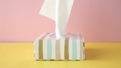 closeup of a tissue box with a pink and yellow background