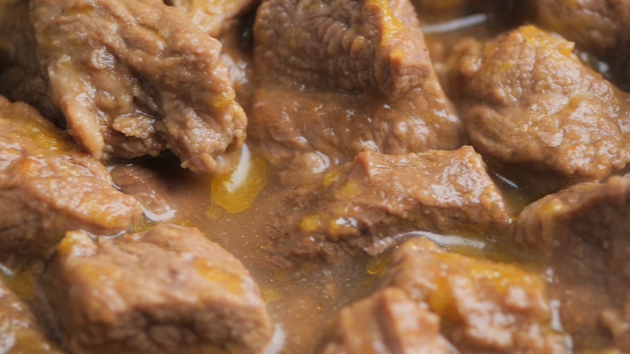 Close-up of Steaming Meat Chunks in Savory Gravy