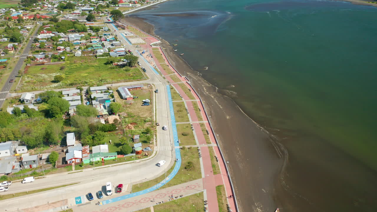 Aerial dolly shot over the coastal town of Puerto Saavedra, Araucania, Chile, bright sunny daylight.