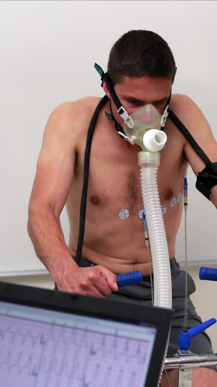 hombre en forma haciendo una prueba de estrés en una bicicleta de ejercicio observado por un médico