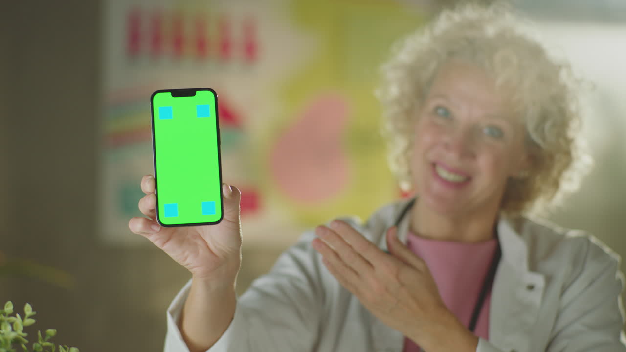 médico sosteniendo un teléfono inteligente con pantalla verde