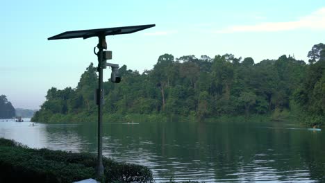 Cámaras-De-Vigilancia-Alimentadas-Por-Paneles-Solares,-El-Movimiento-De-Suaves-Olas-Y-El-Fondo-De-La-Hermosa-Vista-Del-Embalse-De-Macritchie-En-Singapur